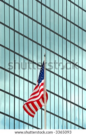 American flag flying in front of steel and glass office building facade