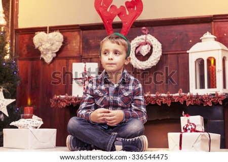 young boy waiting for santa claus sitting on the table