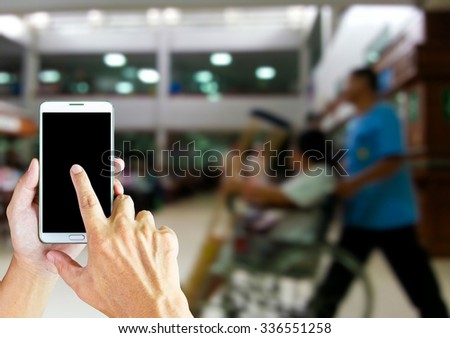 Man use smart phone , blur image of the halls in the hospital is background.