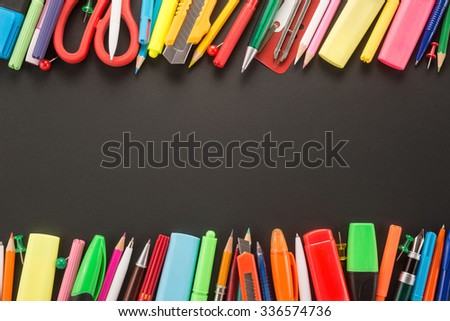 School office supplies on black background 
