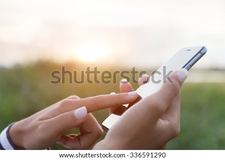 hand using phone outdoor at sunset Royalty-Free Stock Photo #336591290