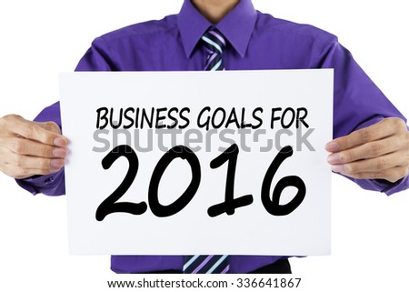 Photo of male entrepreneur holding a paper with a text of business goals for 2016, isolated on white background