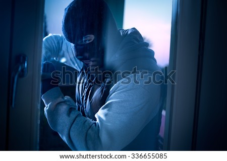 
burglar with crowbar to break door to enter the house Royalty-Free Stock Photo #336655085