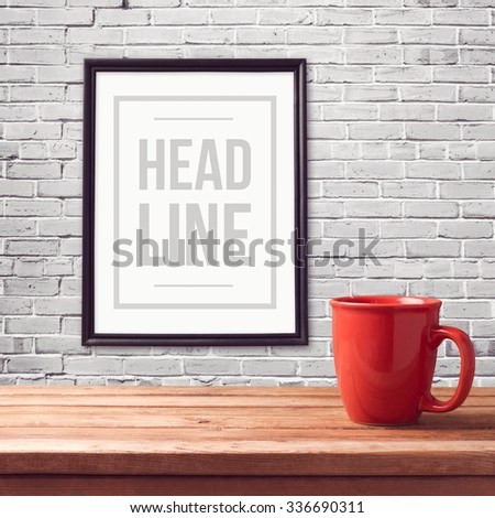 Poster mock up template with red cup on wooden table over brick white wall