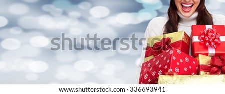 Beautiful Woman with Xmas gift over Christmas background.