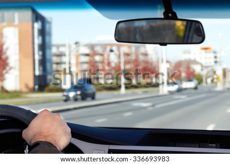 Hand of man driving on a highway. Driver insurance concept.