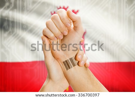 Barcode ID number on wrist of a human and national flag on background - Gibraltar