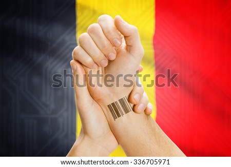 Barcode ID number on wrist of a human and national flag on background - Belgium