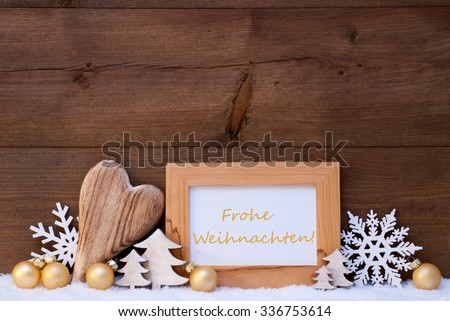 Golden Christmas Decoration On Snow. Heart, Christmas Tree Balls, Snowflake, Christmas Tree. Picture Frame With German Text Frohe Weihnachten Mean Merry Christmas. Rustic, Vintage Wooden Background. 