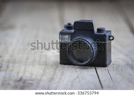 Close-up view of old small toy camera on wooden background