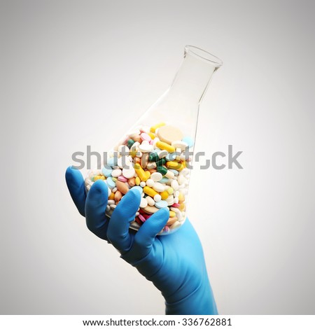 A lot of pills in the Erlenmeyer flask in the hand