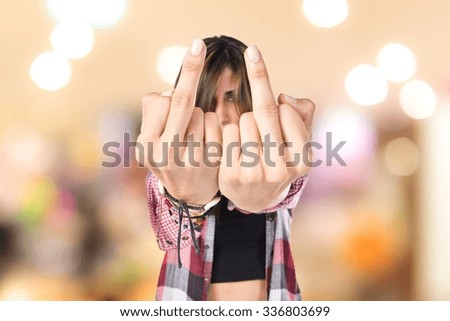 Girl making horn gesture over unfocused background