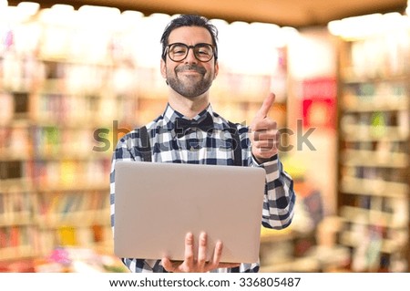 Posh boy with laptop on unfocused background
