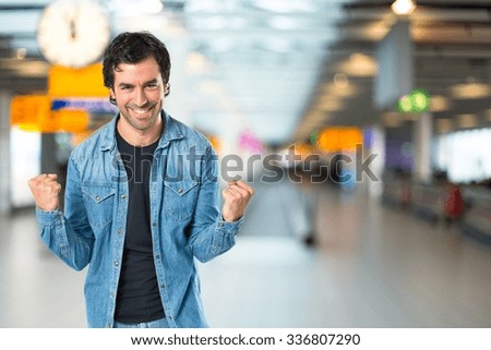 Lucky young man on unfocused background