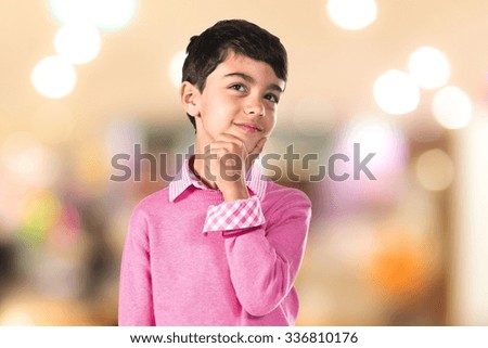 Kid thinking  on unfocused background