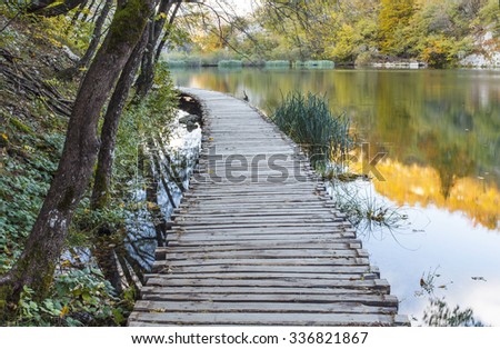 Autumn majestic view on turquoise water with wooden path road in the Plitvice Lakes National Park. Croatia.