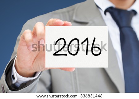 Businessman hand holding card with 2016 message.