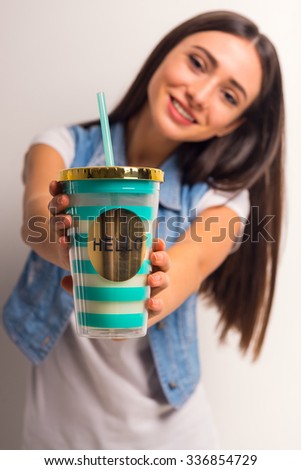 Portrait of a cheerful teenager girl drinking juice on a white background
