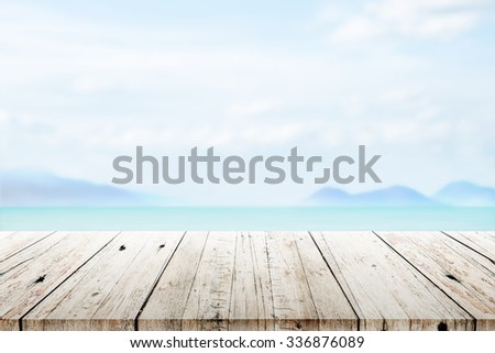 old wood table top on blurred beach background 