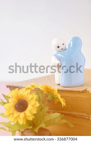 Little ceramic dolls on book background