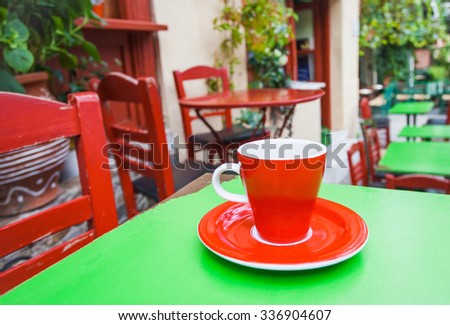 A cup of coffee on table with old street at the background, Southern Europe