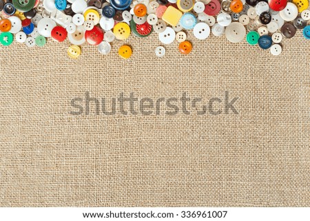Colourful sewing buttons on fabric texture background with copy space