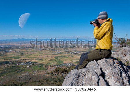 Hiker photographer taking picture of the valley with mountains 