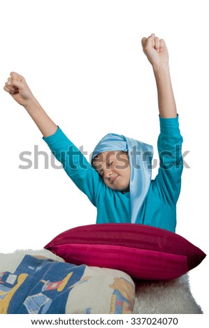 Cute boy near maroon pillow  stretching his self isolated on white