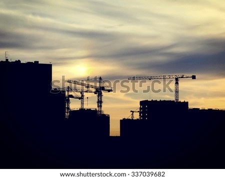 Silhouette of Building and Crane Under Construction on the Evening Sky Background