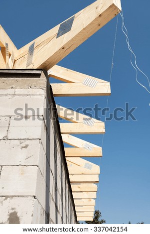 Installation of wooden beams, roof rafters at roof construction. New house made with autoclaved aerated concrete blocks