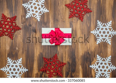 white Gift red silk wrap  for holiday event with Snowflake on wooden background