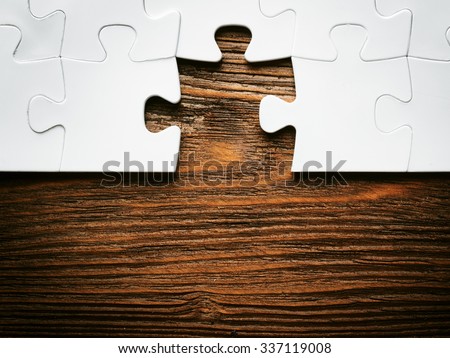 Placing missing a piece of puzzle. business concept. wooden background
