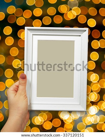 Wooden frame in beautiful woman hands on the background christmas bokeh