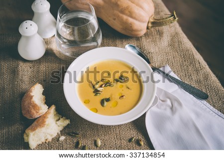 Roasted pumpkin and carrot soup and pumpkin seeds. Toned picture