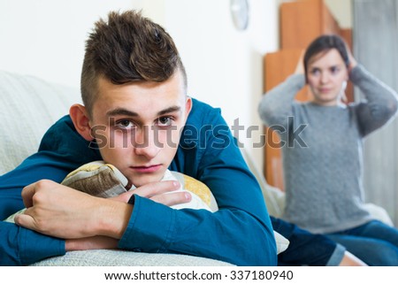 Frustrated mother scolding teenager son at home. focus on american boy Royalty-Free Stock Photo #337180940