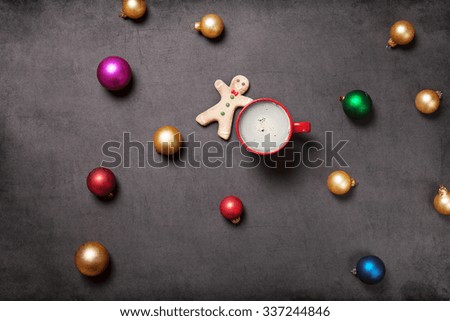 Cup of coffee and gingerbread man on grey background