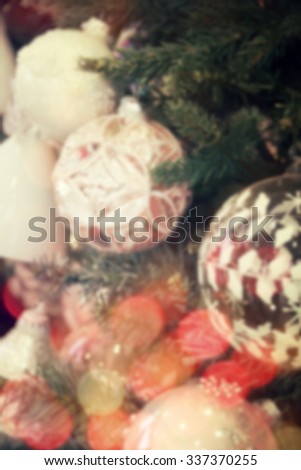 Blurred christmas decorations hanging on christmas tree with light bokeh.