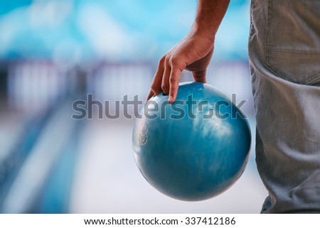 Young man in jeans holding bowling ball