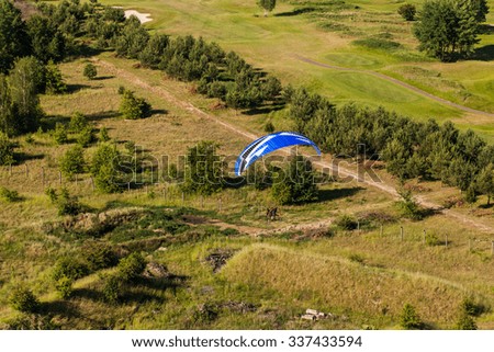 aerial view of paramotor flying over the fields in summer