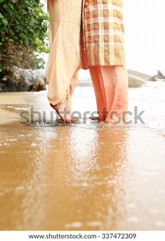 Young couple legs on the beach sand. Travel summer tropic holidays. Sunset silhouette of kissing newlyweds lovers hugging in front of ocean. Honeymoon vacation romantic sea view on Seychelles islands