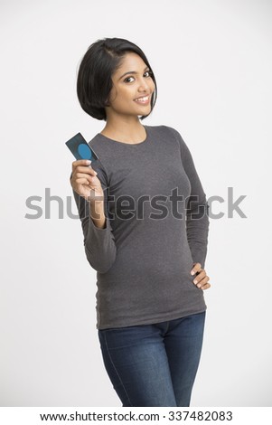 Happy Indian young girl showing credit card on white.