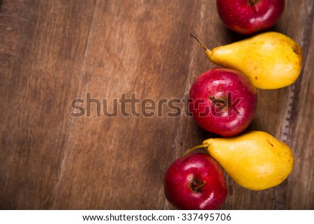 fresh autumn apples and pears on wooden background