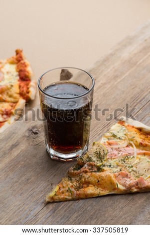 Delicious sliced salmon pizza and coke on a wooden table