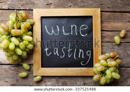 old chalk scripted frame with grape on wooden background