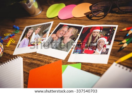 High angle view of office supplies and blank instant photos against portrait of smiling little girl at christmas dinner