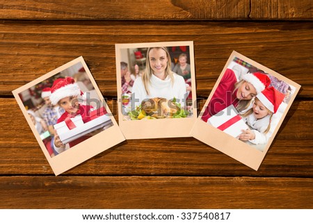 Instant photos on wooden floor against festive daughter holding pile of gifts with his family behind