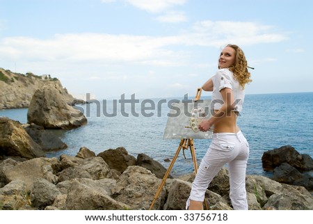 The young beautiful woman draws a picture