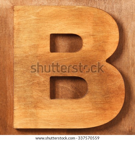 Old wooden letter B on wooden background
