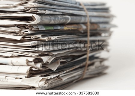 A tied stack of newspapers. Focus on near edge of stack.