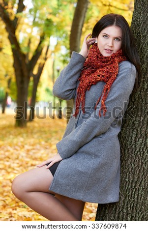 girl portrait with red scarf in autumn city park, fall season